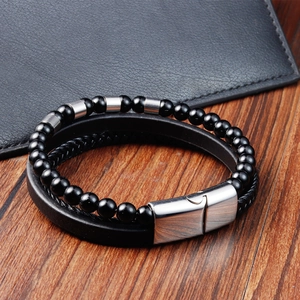 Detail of men's triple-layer braided leather bracelet with black beads and magnetic clasp