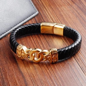 Close-up of black braided leather men's bracelet with gold magnetic clasp and geometric totem