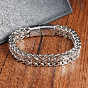 Men's double-layered silver stainless steel braided bracelet on a wooden table