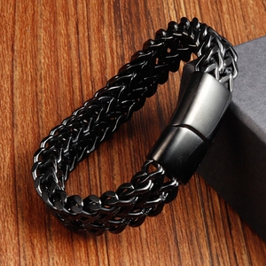 Detail of men's double-row braided leather bracelet with matte black magnetic clasp