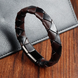 Detailed macro view of woven brown leather bracelet with matte black magnetic metal clasp