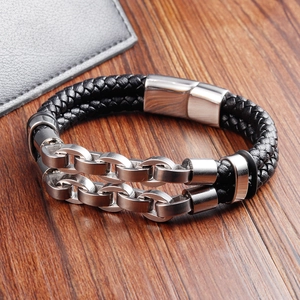 Detail of double-layer men's braided leather bracelet with stainless steel chains on wood