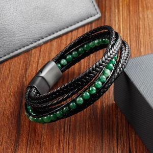 Macro view of braided black leather layers and green stone beads with metal magnetic clasp