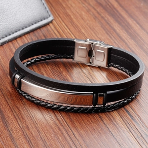 Detailed view of black woven leather layers and stainless steel magnetic clasp on mens bracelet