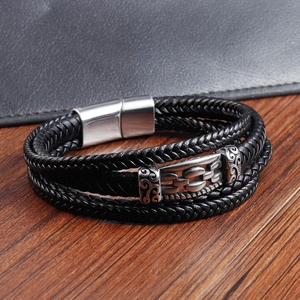 Close-up of black braided leather bracelet with vintage scroll pattern magnetic clasp
