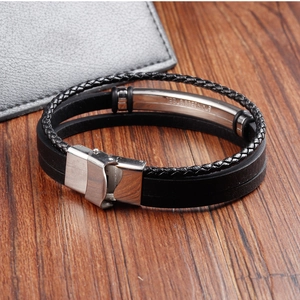 Close-up of black braided leather bracelet with stainless steel magnetic clasp and engraving
