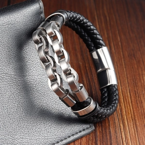 Detail of multi-layer braided black leather bracelet with double silver steel chains