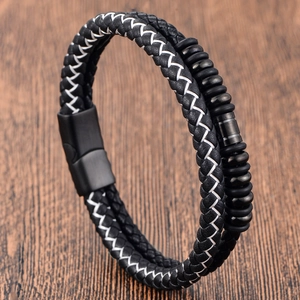 Men's double-layered black woven leather bracelet with matte magnetic buckle on wood