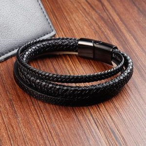 Nahaufnahme von schwarzem Lederarmband für Herren mit mattem Metallverschluss auf Holz