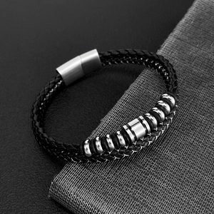 Detail of black multi-strand woven leather bracelet with silver polished metal magnetic clasp
