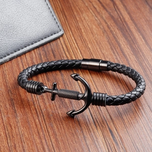 Close-up of black braided leather anchor bracelet for men on rustic wood background