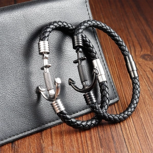Detail showing braided black leather bracelets with silver and black anchor-shaped clasps