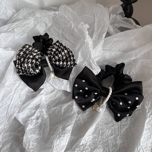 Detail of French polka dot and houndstooth bow hair ties with pearl and gold charms