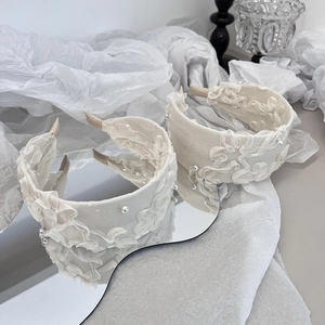 Serre-tête beige élégant avec froufrous en dentelle et perles sur fond blanc texturé