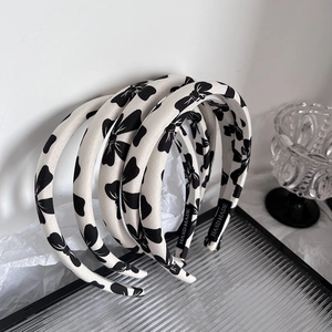 Polka dot bow sponge headbands in cream fabric on a glass plate with handmade label