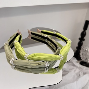 Detail showing two handmade green satin headbands with pearl flower clusters