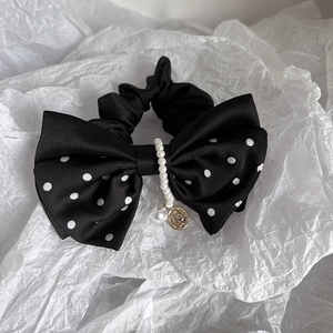 Detail of polka dot bow scrunchie with faux pearls and vintage golden charm