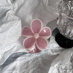 Detail shot of a candy pink jelly flower hair claw clip on a modern mirror base
