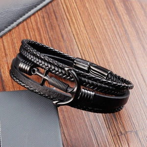 Detailed close-up of multilayer black leather braid bracelet with a metal anchor charm