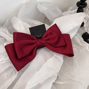 Détail d'un élégant nœud papillon en satin bordeaux avec une texture de soie raffinée