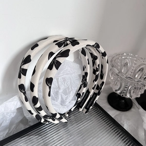Three-piece set of cream fabric headbands with black bow patterns and handmade labels