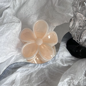 Detail of a creamy pink jelly flower hair claw clip with transparent edges and resin texture