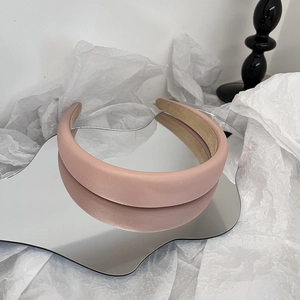 Detail eines hellrosa breiten Satin-Haarreifens mit sauberer Naht und rutschfestem Futter