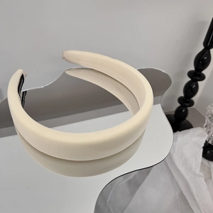 Détail du serre-tête en éponge beige avec texture de tissu épais sur surface réfléchissante