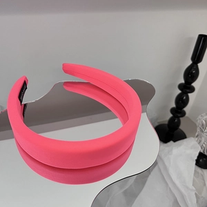 Détail d'un serre-tête en éponge rose sur un miroir avec étiquette fait main