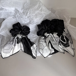 Detailed view of floral rose pattern on satin hair scrunchies with elegant long ribbons