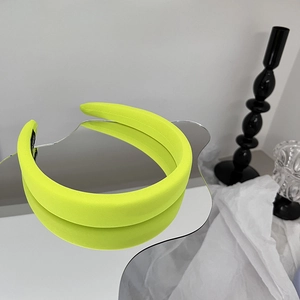 Détail d'un serre-tête large vert néon avec doublure antidérapante sur fond miroir
