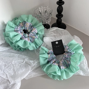 Floral ruffle scrunchie in mint green and purple, featuring handmade designer label