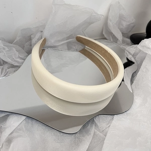 Detailansicht des gepolsterten Haarreifs in Creme mit Ledertextur und rutschfestem Futter