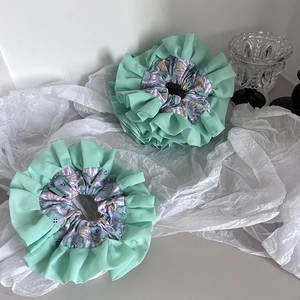 Detail of mint green floral scrunchies with Hand Made label on soft paper background
