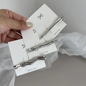 Minimalist silver alloy hair pins in straight and wavy designs on display card
