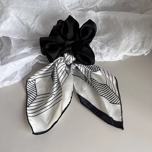 Navy blue striped satin bow scrunchie with geometric patterns for elegant hair styling
