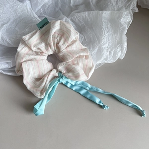 Détail d'un chouchou rayé rose avec ruban bleu et étiquette Hand Made artisanale