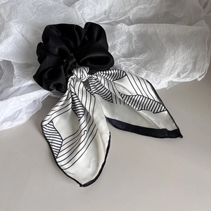 Detailed close-up of navy blue striped satin bow scrunchie with silk ribbon texture