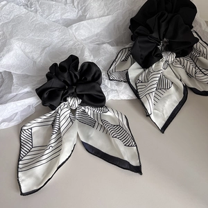 Close-up of elegant navy striped satin bow scrunchies with smooth fabric texture