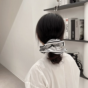 Close-up of black and white striped hair scrunchie with chain print on low ponytail
