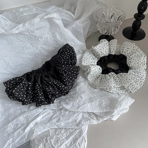 Detailed view of polka dot pattern large scrunchies in black and white chiffon fabric
