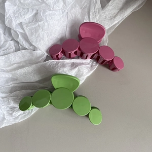 Minimalist summer hair claw clips in rose red and grass green with circular layered design