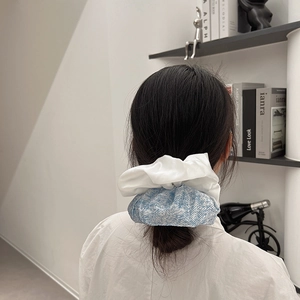 Chouchou élégant en tissu bleu et blanc porté en queue de cheval pour un style ballet