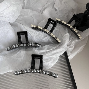 Eleganti mollette per capelli nere con perle e strass su vassoio di vetro moderno