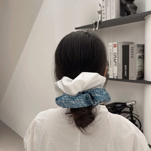 Chouchou géant en satin bleu et blanc porté sur un chignon élégant pour femme