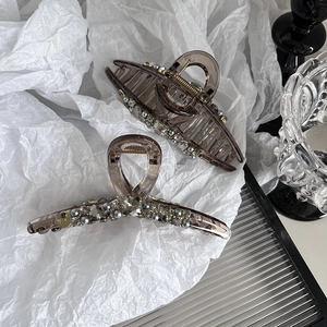 Lot de pinces à cheveux marron avec perles et cristaux sur fond esthétique épuré