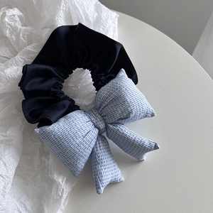Detailed view of the blue plaid bow hair scrunchie with satin fabric and elegant design