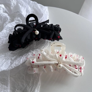 Detail of elegant black and white polka dot chiffon hair claws with pearl charms