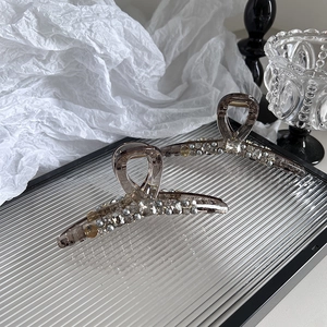 Pinces à cheveux marron avec cristaux et perles sur un plateau en verre décoratif
