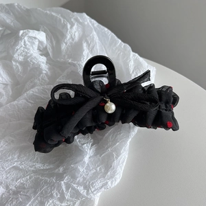 Detailed shot of black polka dot chiffon hair claw with red dots and pearl pendant